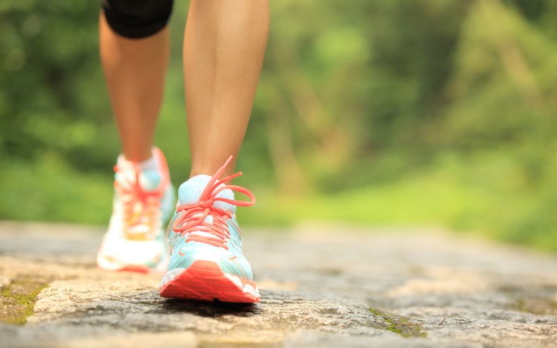 fitness woman hiker feet hiking on stone trail